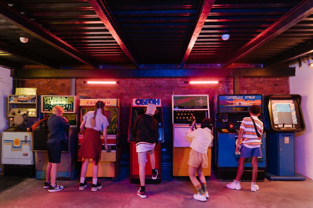 A group of friends in the 1980s play at an arcade